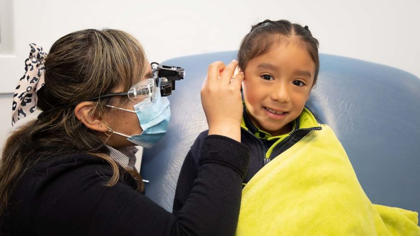 A child has her ear inspected at Earworx